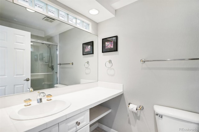 bathroom featuring vanity, toilet, visible vents, and a stall shower