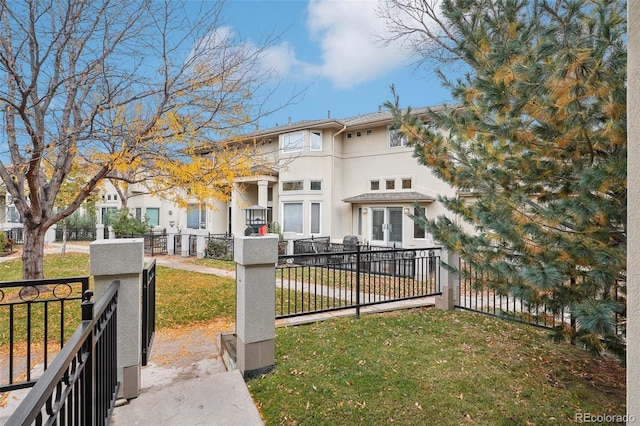 mediterranean / spanish home featuring a gate, french doors, a fenced front yard, and stucco siding