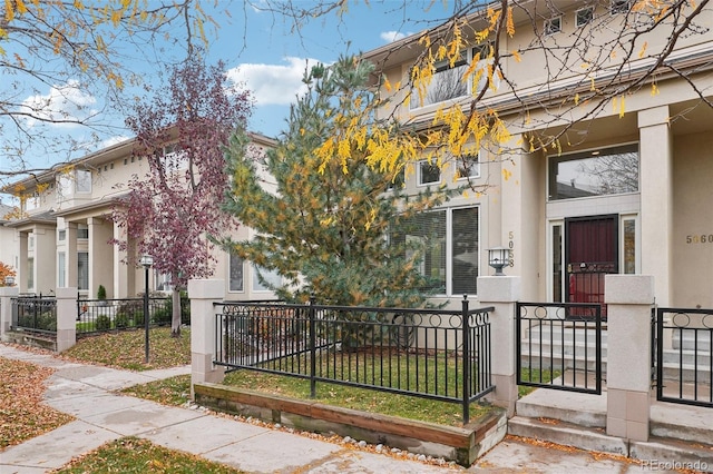 view of front of home with a fenced front yard and stucco siding