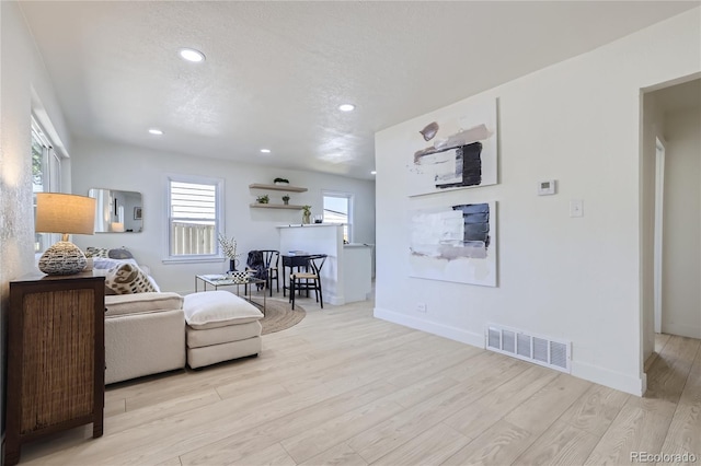 living room featuring a textured ceiling and light hardwood / wood-style floors