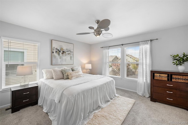 bedroom with ceiling fan, light carpet, and baseboards