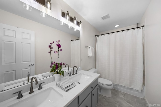 full bathroom featuring double vanity, toilet, marble finish floor, and a sink