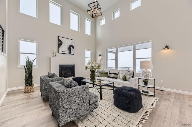 living room with an inviting chandelier and light wood-type flooring