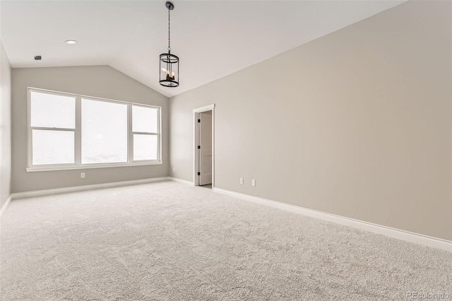 carpeted empty room with vaulted ceiling