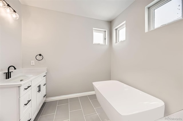 bathroom featuring vanity, tile patterned floors, and a tub