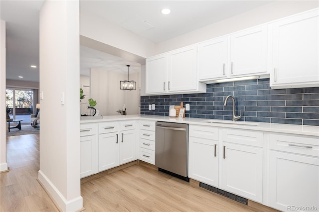 kitchen with white cabinetry, sink, stainless steel dishwasher, and light hardwood / wood-style floors