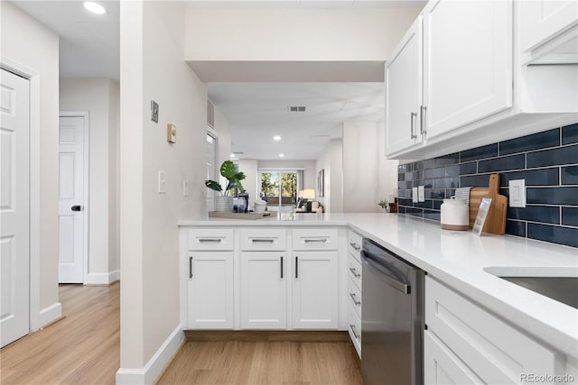 kitchen featuring kitchen peninsula, tasteful backsplash, dishwasher, light hardwood / wood-style floors, and white cabinetry