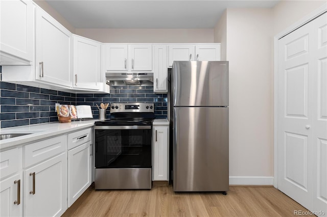 kitchen with appliances with stainless steel finishes, tasteful backsplash, light stone counters, light hardwood / wood-style floors, and white cabinetry