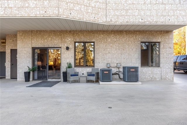 doorway to property featuring central AC unit and a patio