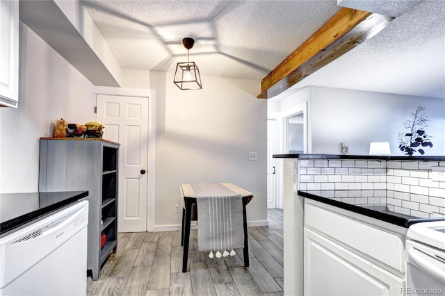 kitchen featuring decorative light fixtures, light wood-type flooring, white cabinetry, and a textured ceiling