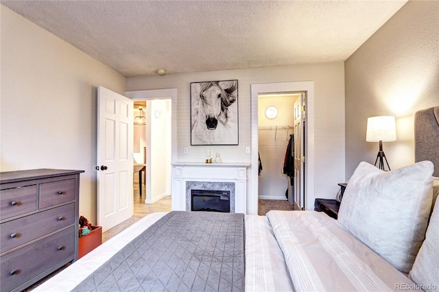 carpeted bedroom featuring a closet, a spacious closet, and a textured ceiling