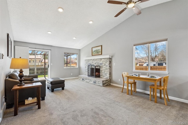 carpeted living room with a fireplace, baseboards, and a ceiling fan