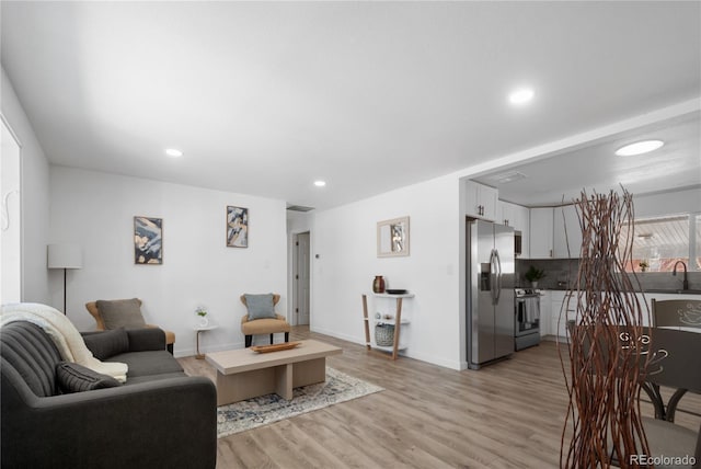 living room with sink and light hardwood / wood-style floors