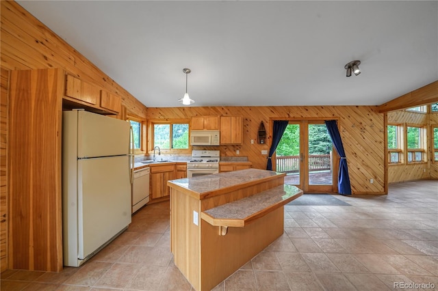 270 River Run Dr, Antonito, CO 81120 - kitchen with white appliances, healthy amount of natural light, tile counters, wooden walls, and a center island
