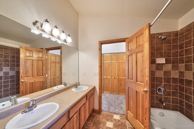 270 River Run Dr, Antonito, CO 81120 - bathroom featuring washtub / shower combination, double vanity, and stone finish floors