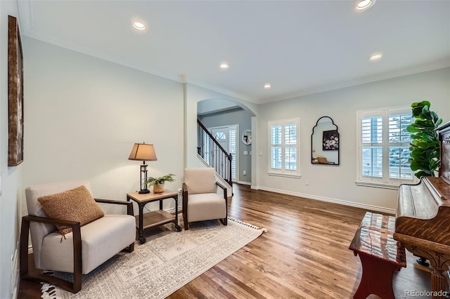 living area with baseboards, stairway, recessed lighting, wood finished floors, and arched walkways