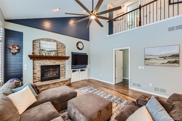 living room with ceiling fan, visible vents, and wood finished floors