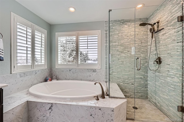 bathroom with vanity, a garden tub, and a shower stall