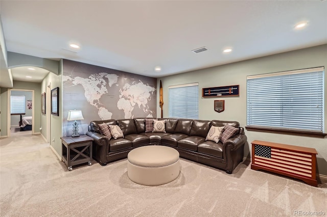 carpeted living area with recessed lighting, visible vents, arched walkways, and baseboards