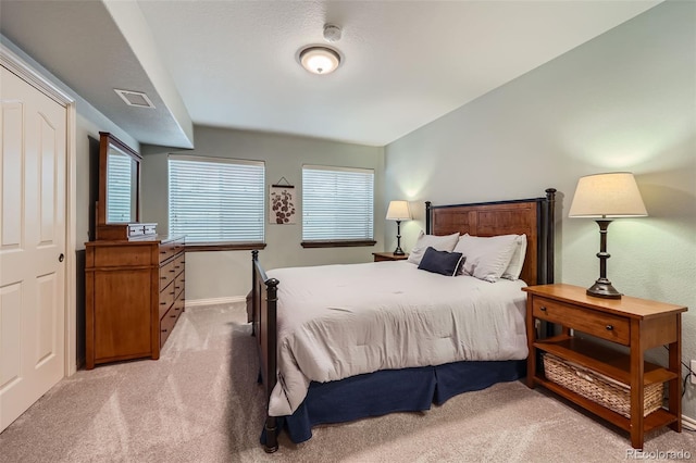 bedroom featuring light carpet, visible vents, and baseboards