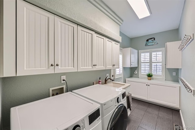 laundry area featuring washer and dryer, visible vents, cabinet space, and a sink