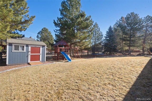 view of playground featuring an outdoor structure, a trampoline, a lawn, and a shed