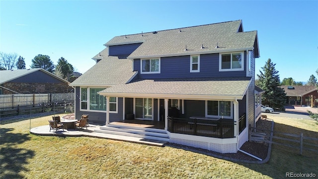 back of property with a patio, fence, roof with shingles, a yard, and a fire pit