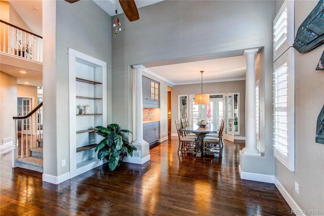 interior space with ornamental molding, dark hardwood / wood-style flooring, and ornate columns