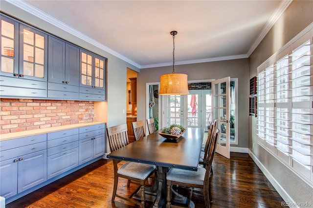 dining room featuring french doors, dark hardwood / wood-style flooring, a wealth of natural light, and crown molding