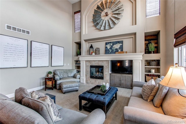 carpeted living room with a towering ceiling and a fireplace