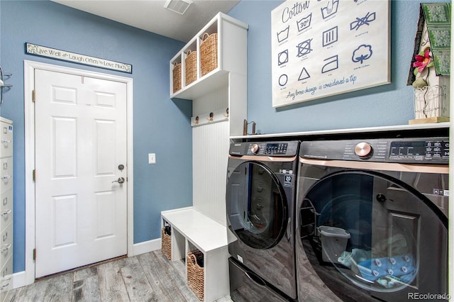 washroom featuring light wood-type flooring and washer and clothes dryer