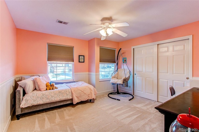 carpeted bedroom featuring ceiling fan and a closet