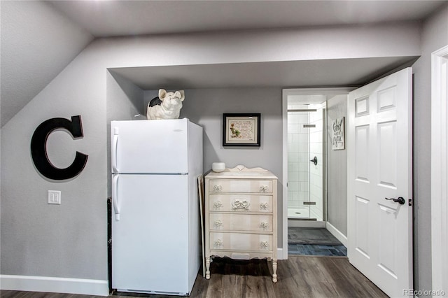 kitchen featuring white refrigerator, lofted ceiling, and dark wood-type flooring