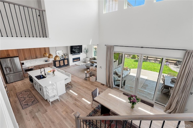 9140 Moondance Dr, Littleton, CO 80125 - living area with a towering ceiling, light wood-type flooring, and a glass covered fireplace