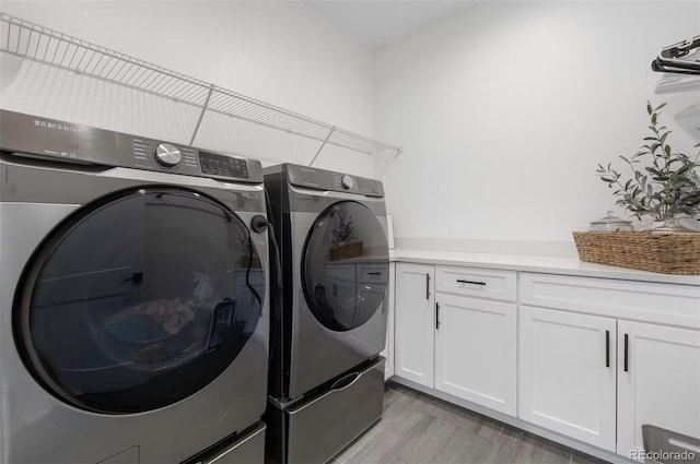 9140 Moondance Dr, Littleton, CO 80125 - laundry room featuring washer and clothes dryer, cabinet space, and light wood-style flooring
