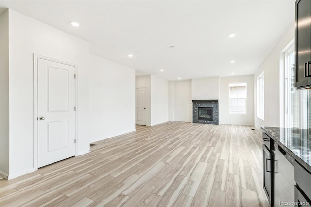 unfurnished living room featuring light hardwood / wood-style floors and a high end fireplace