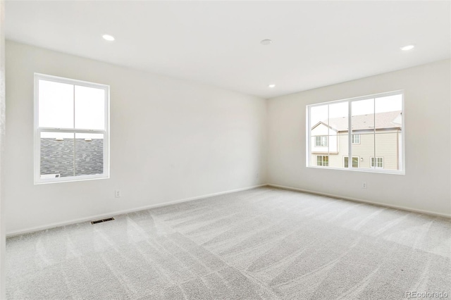 empty room featuring light colored carpet and a wealth of natural light