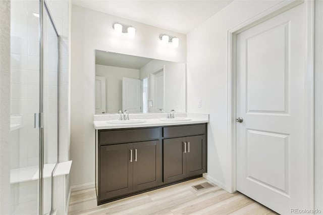 bathroom with hardwood / wood-style floors, vanity, and walk in shower