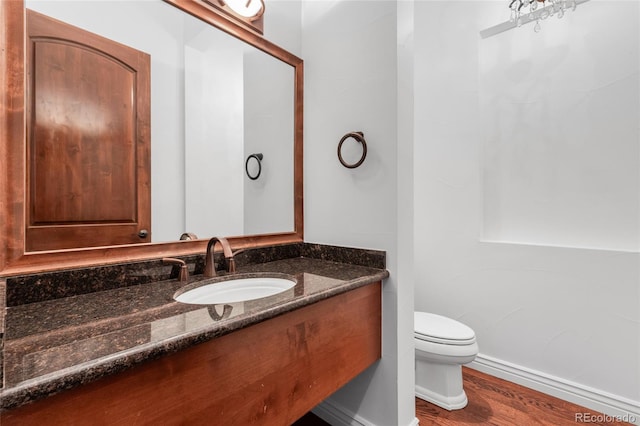 bathroom with hardwood / wood-style flooring, vanity, and toilet