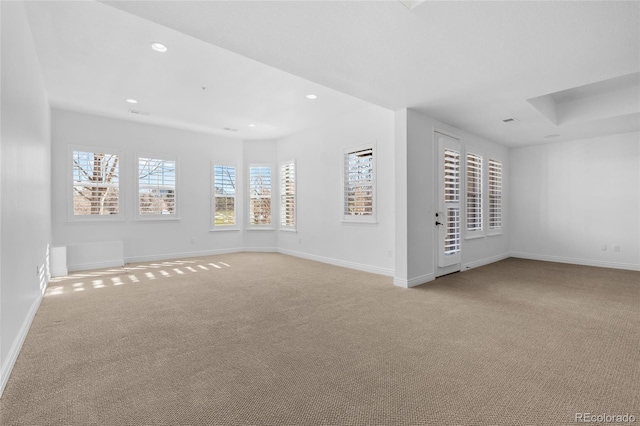 empty room featuring recessed lighting, baseboards, and light colored carpet