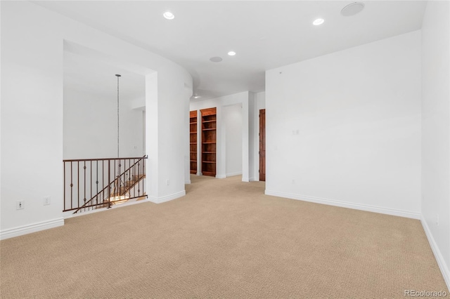 spare room with baseboards, light colored carpet, and recessed lighting