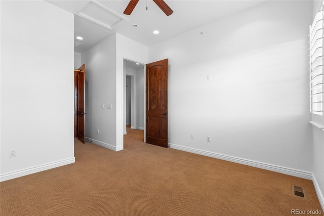 empty room featuring recessed lighting, visible vents, attic access, light carpet, and baseboards