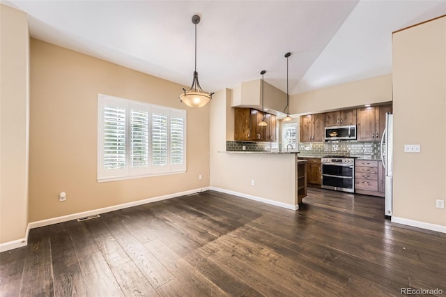 2761 W 106th Loop Unit C, Denver, CO 80234 - kitchen with appliances with stainless steel finishes, tasteful backsplash, lofted ceiling, dark wood-style floors, and hanging light fixtures