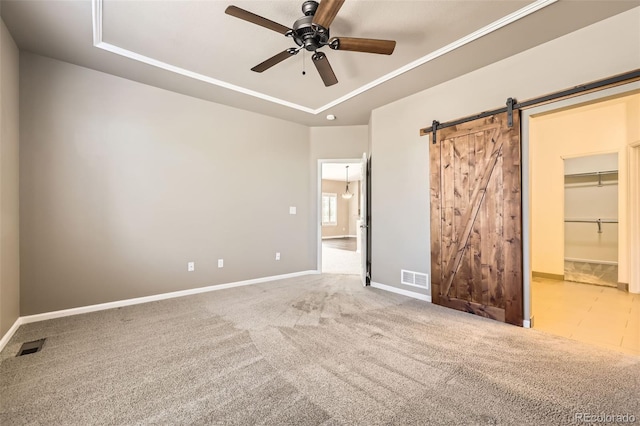 2761 W 106th Loop Unit C, Denver, CO 80234 - unfurnished bedroom with a tray ceiling, a barn door, and carpet floors