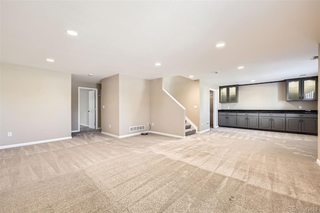 2761 W 106th Loop Unit C, Denver, CO 80234 - unfurnished living room featuring light colored carpet, baseboards, stairs, and recessed lighting