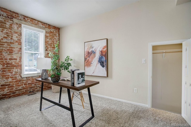 office space featuring light carpet and brick wall