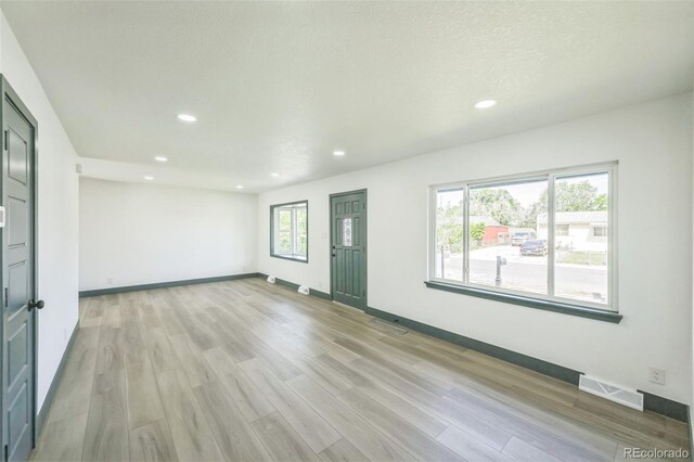 7810 Larkwood St, Commerce City, CO 80022 - unfurnished living room with recessed lighting and light wood-style floors