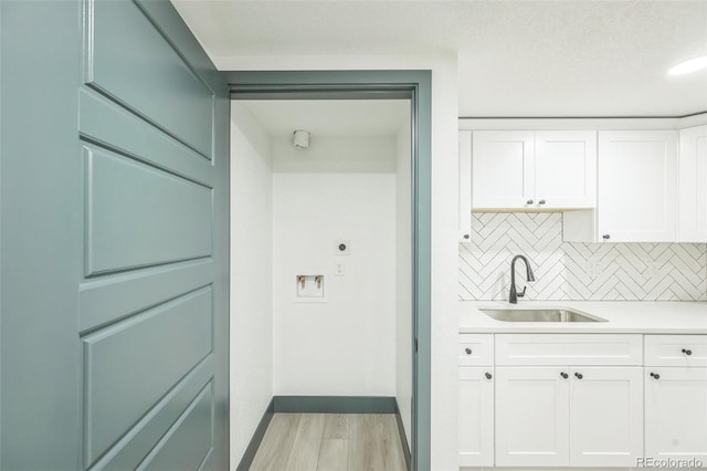 7810 Larkwood St, Commerce City, CO 80022 - laundry room featuring light wood-type flooring, hookup for an electric dryer, cabinet space, hookup for a washing machine, and bar with sink