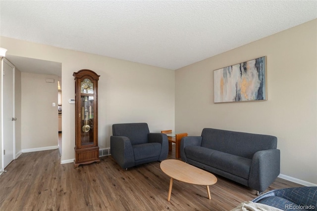 living area with a textured ceiling and hardwood / wood-style flooring