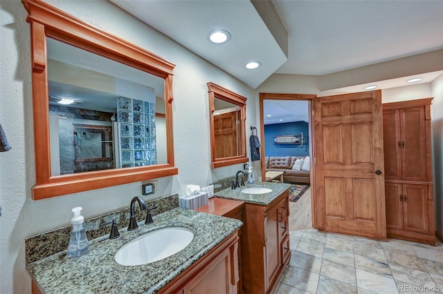 full bathroom featuring two vanities, a sink, and recessed lighting